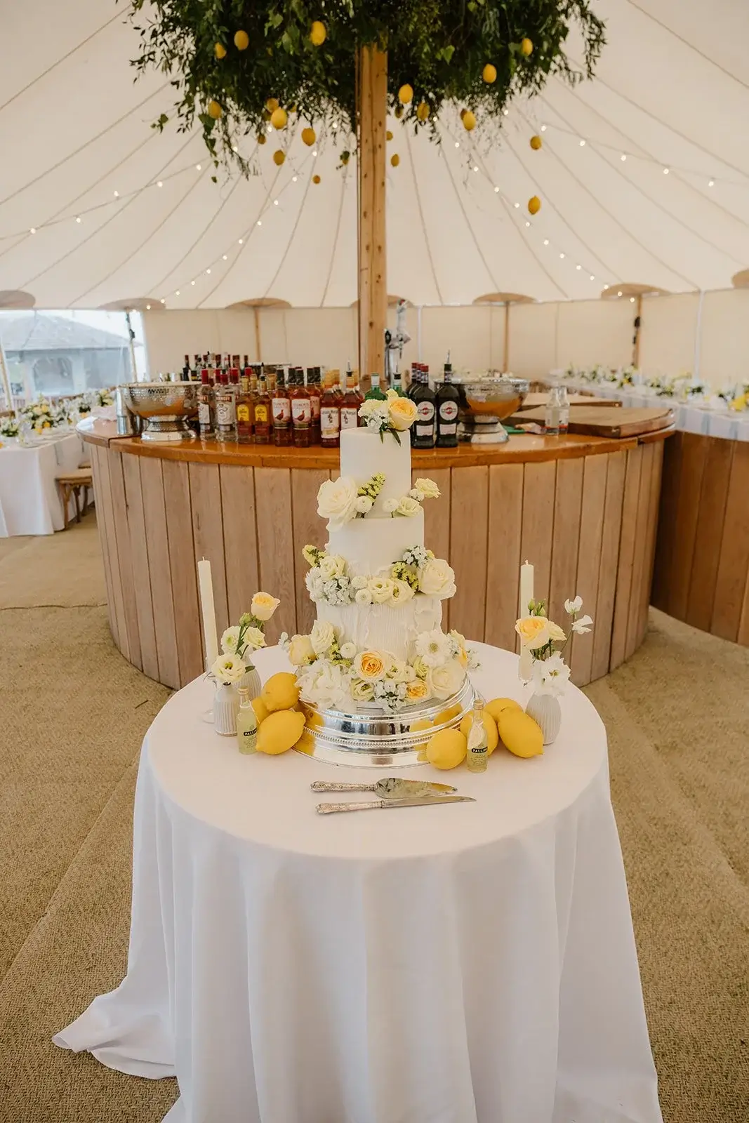 Tiered wedding cake trimmed with lemons and buttercream blooms