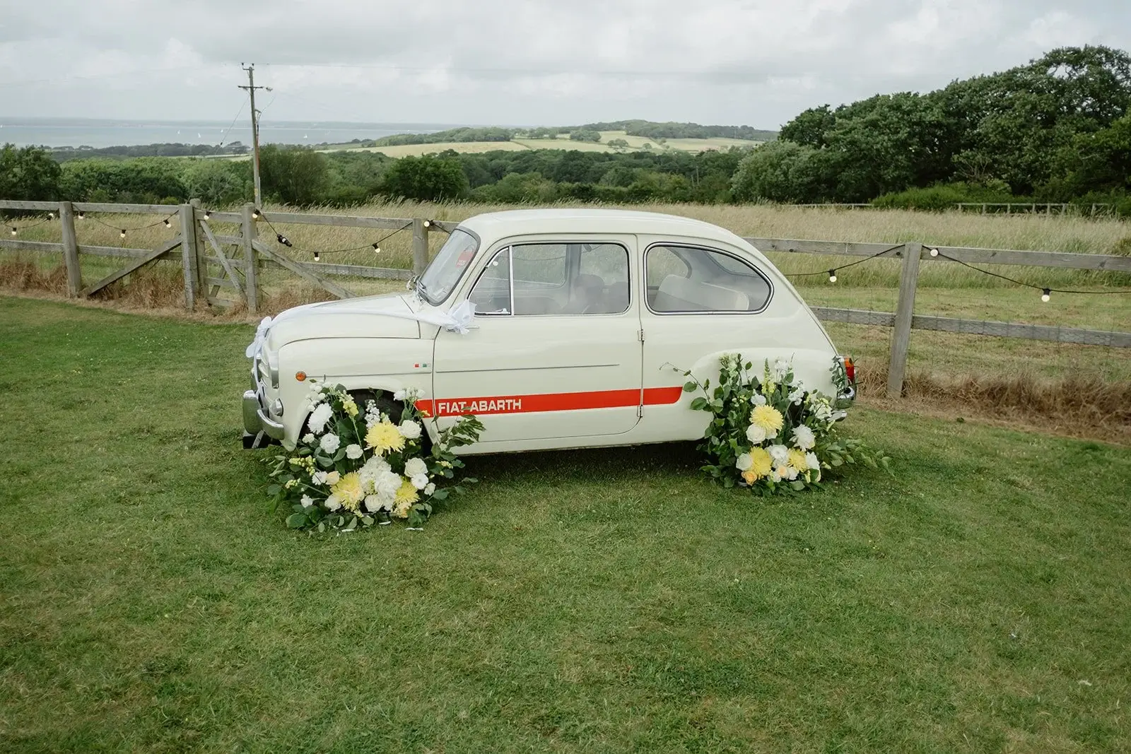 Vintage Fiat Abarth parked among long grasses at the private family home