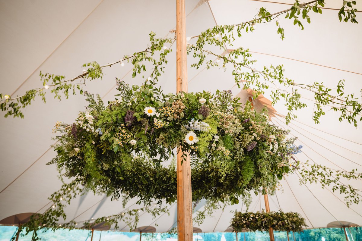 Ring of foliage and ox-eye daisies hanging from the centre pole of the dining tent