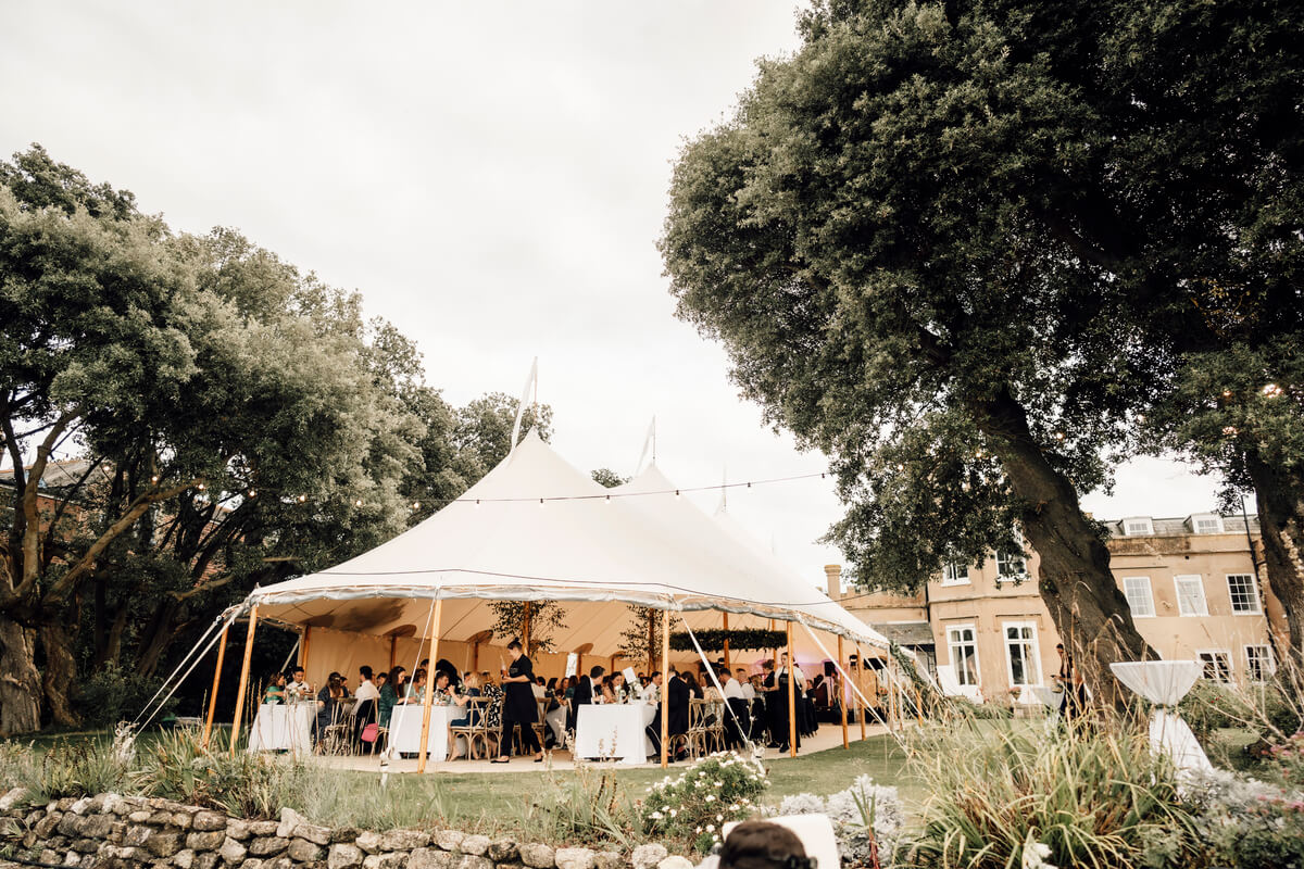 Sailcloth tent reception in the gardens beside The Towers under soft afternoon light