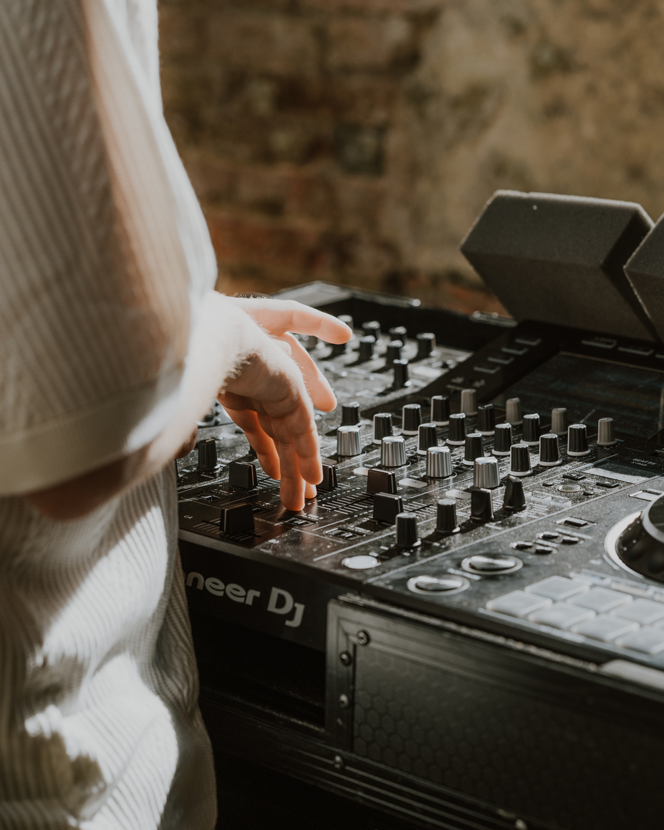 Close up of a hand adjusting knobs on a Pioneer DJ mixing deck during the party