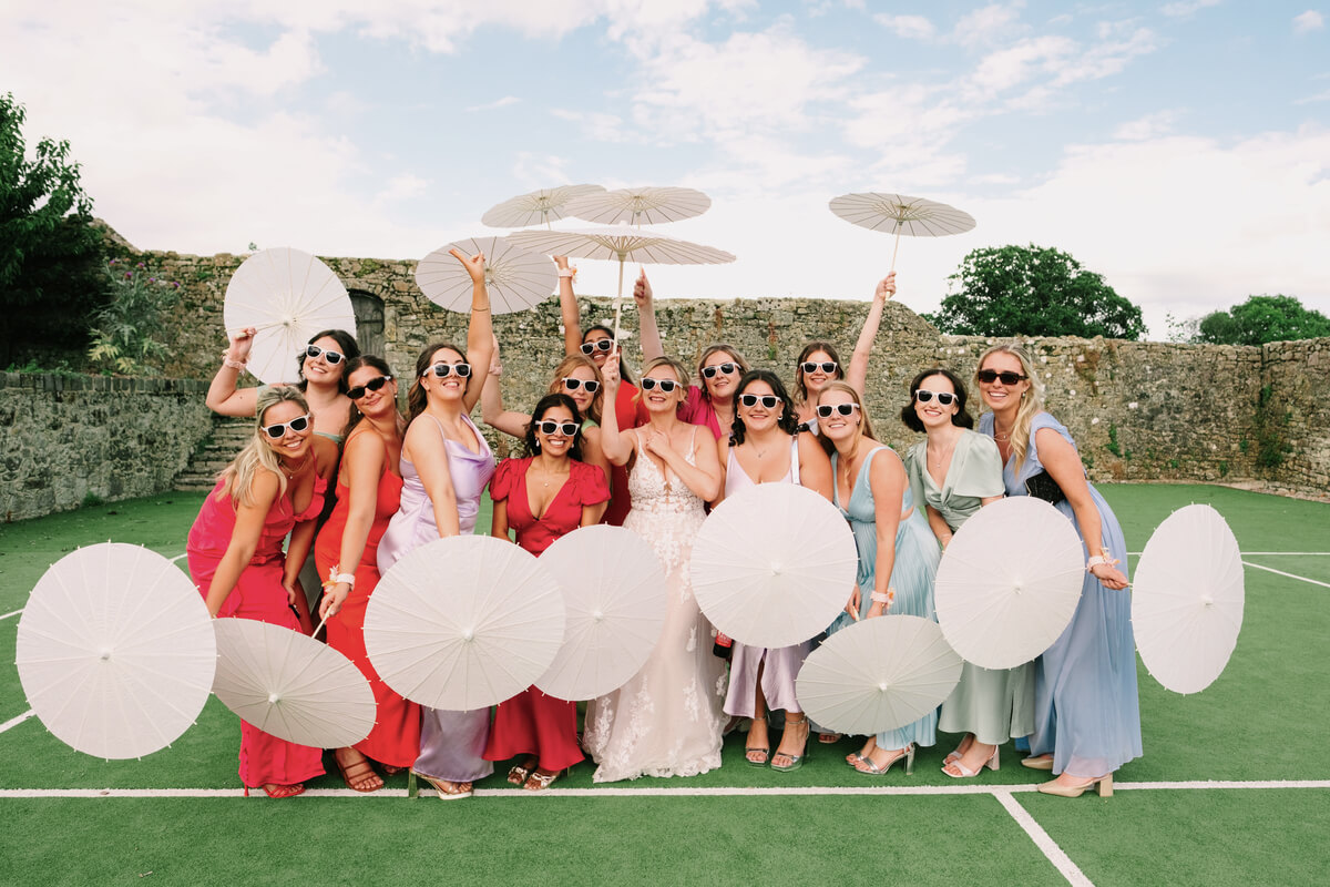 Bridesmaids in mismatched pastels under white parasols