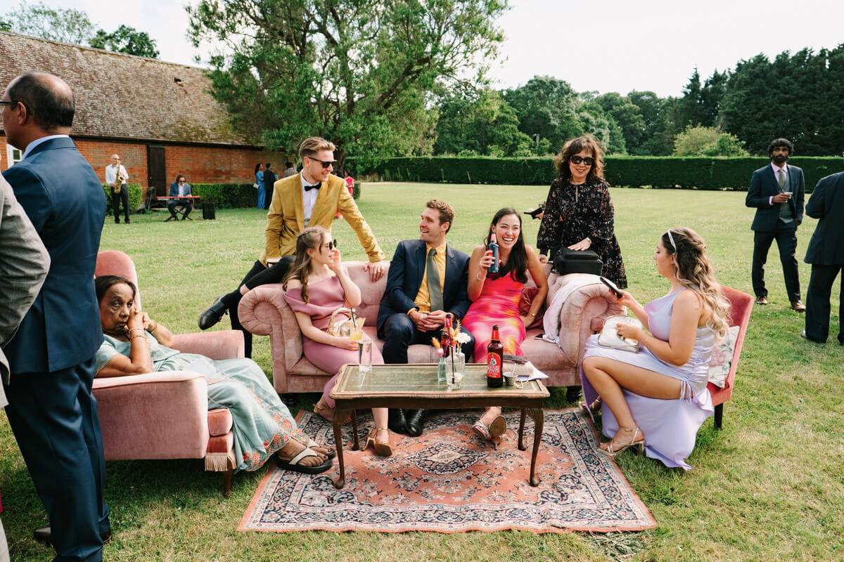 Guests on pink velvet sofas in the garden lounge