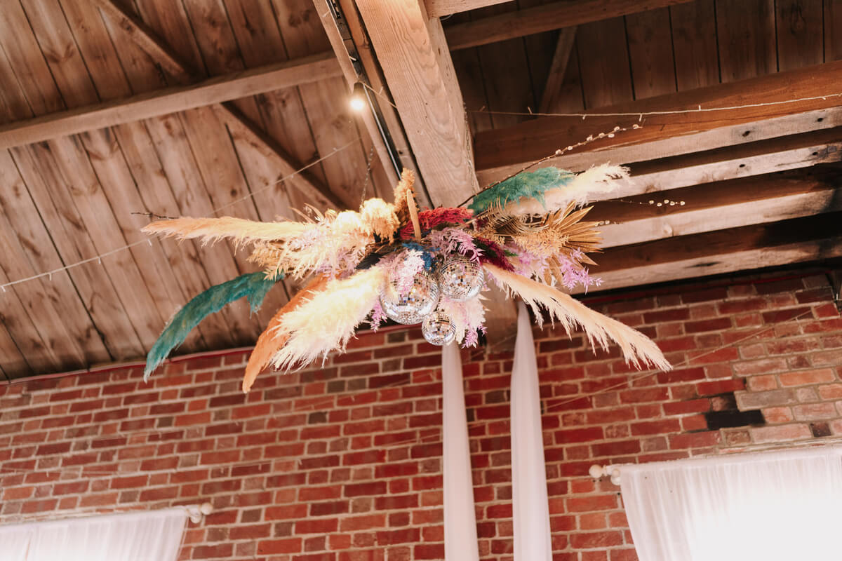Hanging floral installation over the top table in the barn