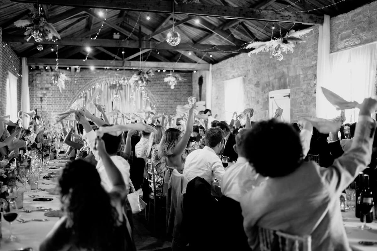 Reception celebration in the barn at Barton Manor in black and white